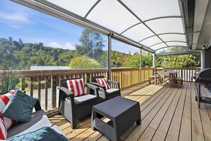 Una terrazza coperta all'aperto con mobili in vimini e un barbecue.