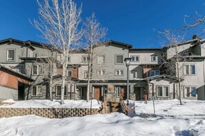 A multi-story residential building with a brick facade, multiple windows, and a staircase leading to the entrance. - Pet Friendly Mountain Hideaway (Mammoth Lakes)