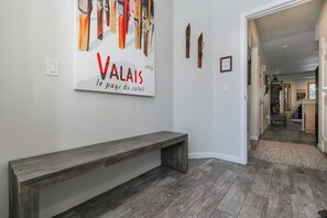 A hallway with a bench, a wall-mounted sign, and a door leading to another room. - Pet Friendly Mountain Hideaway (Mammoth Lakes)