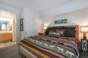 A bedroom with a bed, a headboard, a bedside table, and a sign that reads 'SKILIFT'. - Pet Friendly Mountain Hideaway (Mammoth Lakes)