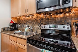 A kitchen with a microwave, stove, and sink. - Pet Friendly Mammoth Studio w/ self check in (Mammoth Lakes)