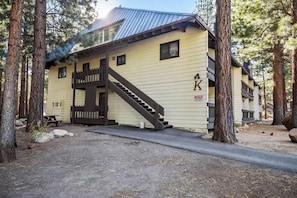 A building with a wooden staircase leading to a door, surrounded by trees. - Pet Friendly Mammoth Studio w/ self check in (Mammoth Lakes)