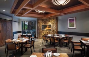 A restaurant with multiple tables and chairs, a fireplace, and a framed picture on the wall. - Pet Friendly Luxury Mammoth Westin Condo (Mammoth Lakes)