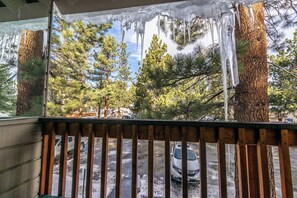 A balcony with a view of a snowy parking lot and trees. - Mammoth Home-Away-From-Home (Mammoth Lakes)