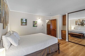 A bedroom with a bed, a wooden door, and a mirror reflecting another bed. - Pet Friendly Classic Mammoth Cabin (Mammoth Lakes)