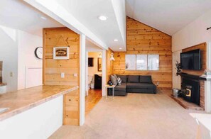A modern interior with a kitchen, living area, and fireplace. - Charming Village Studio Loft (Mammoth Lakes)