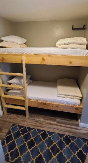 A bunk bed with a wooden ladder, a shelf, and a headboard. - Modern Pet friendly Studio with bunks (Mammoth Lakes)