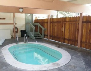 A swimming pool with a wooden deck and a staircase leading to a covered area. - Modern Pet friendly Studio with bunks (Mammoth Lakes)