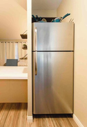 A stainless steel refrigerator in a kitchen with a wooden floor and a white countertop. - Modern Pet friendly Studio with bunks (Mammoth Lakes)