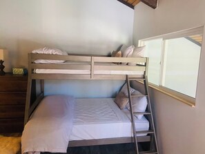 A bunk bed room with a ladder, a window, and a wooden dresser. - Luxury Mammoth 2BR 2BA Townhome (Mammoth Lakes)