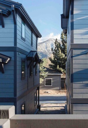 A residential street with houses, a small shed, and a mountain in the background. - Mammoth Mountain Townhome w/ Garage EV Charger (Mammoth Lakes)