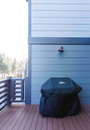 A covered grill on a wooden deck with a blue building in the background. - Mammoth Mountain Townhome w/ Garage EV Charger (Mammoth Lakes)