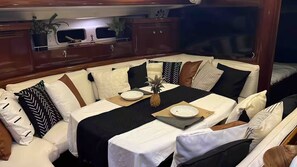 En spiseplads med et bord dækket til to personer, omgivet af polstrede siddepladser.