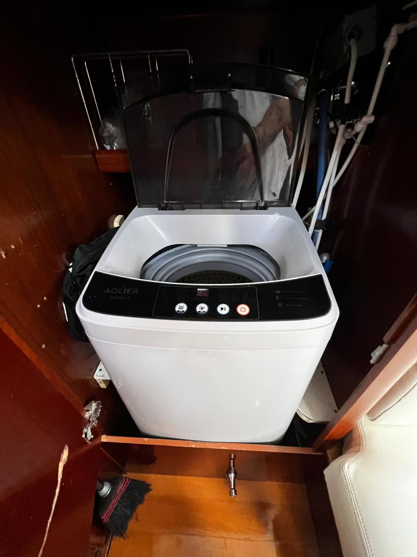 Een compacte, witte wasmachine met voorlader, een bedieningspaneel en een transparante deur.
