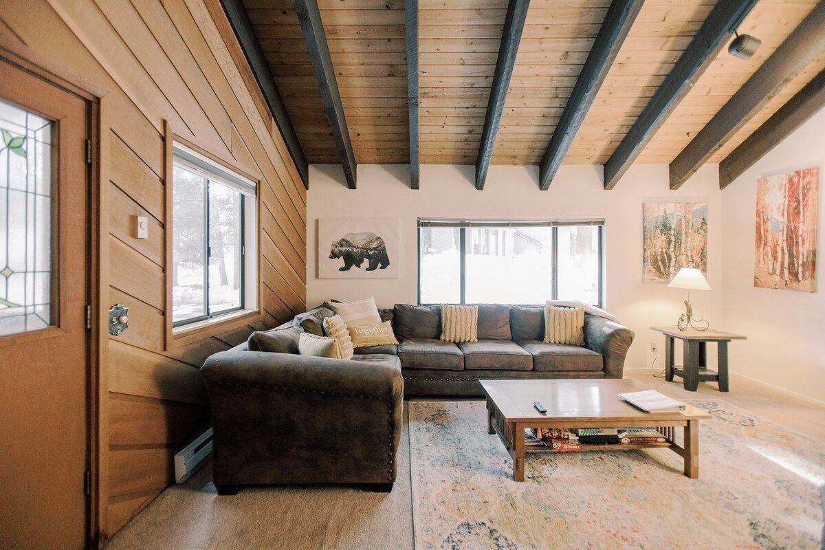 A cozy living room with a sectional sofa, a coffee table, and a fireplace.