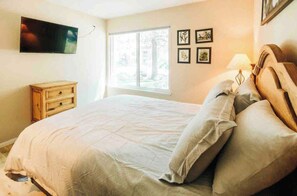 A bedroom with a bed, a television mounted on the wall, a window, and a dresser. - Mammoth Horizon 4 1BD 1BA Family Getaway (Mammoth Lakes)