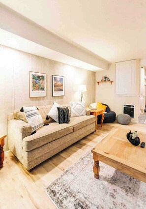 A living room with a sofa, a coffee table, a lamp, and a cat. - Mammoth Horizon 4 1BD 1BA Family Getaway (Mammoth Lakes)