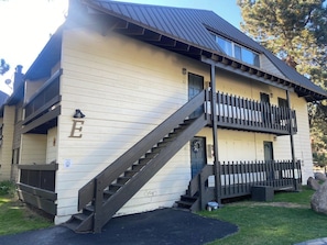 A two-story building with a wooden staircase leading to the entrance. - Pet Friendly 1BR loft 2BA Modern Mammoth Condo (Mammoth Lakes)