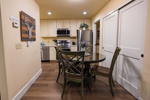 A compact kitchen with a dining table, chairs, a refrigerator, and a microwave. - Pet Friendly 1BD 1BA Mammoth Retreat (Mammoth Lakes)