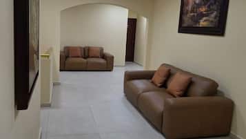 A spacious living area with two sofas and a painting on the wall.