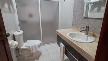 Une salle de bain moderne équipée de toilettes, d’un bidet et d’un lavabo.