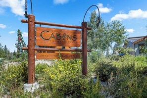 A wooden sign with 'The Cabins Crooked Pines' and '2004 Lodestar Drive' indicating a property name and address. - Mammoth Pet Friendly 2BD 2BA W/ Spectacular Views (Mammoth Lakes)