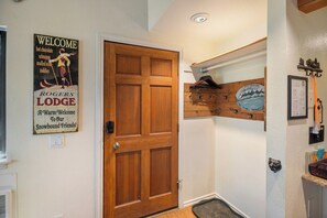 A wooden door with a welcome sign, a coat rack, and a small wooden shelf with a welcome sign. - Gorgeous Hidden Valley Loft w/ a view (Mammoth Lakes)