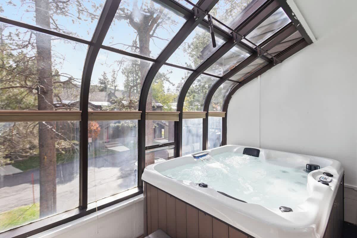 Ein Whirlpool in einem Zimmer mit großem Fenster mit Blick auf eine Wohngegend.