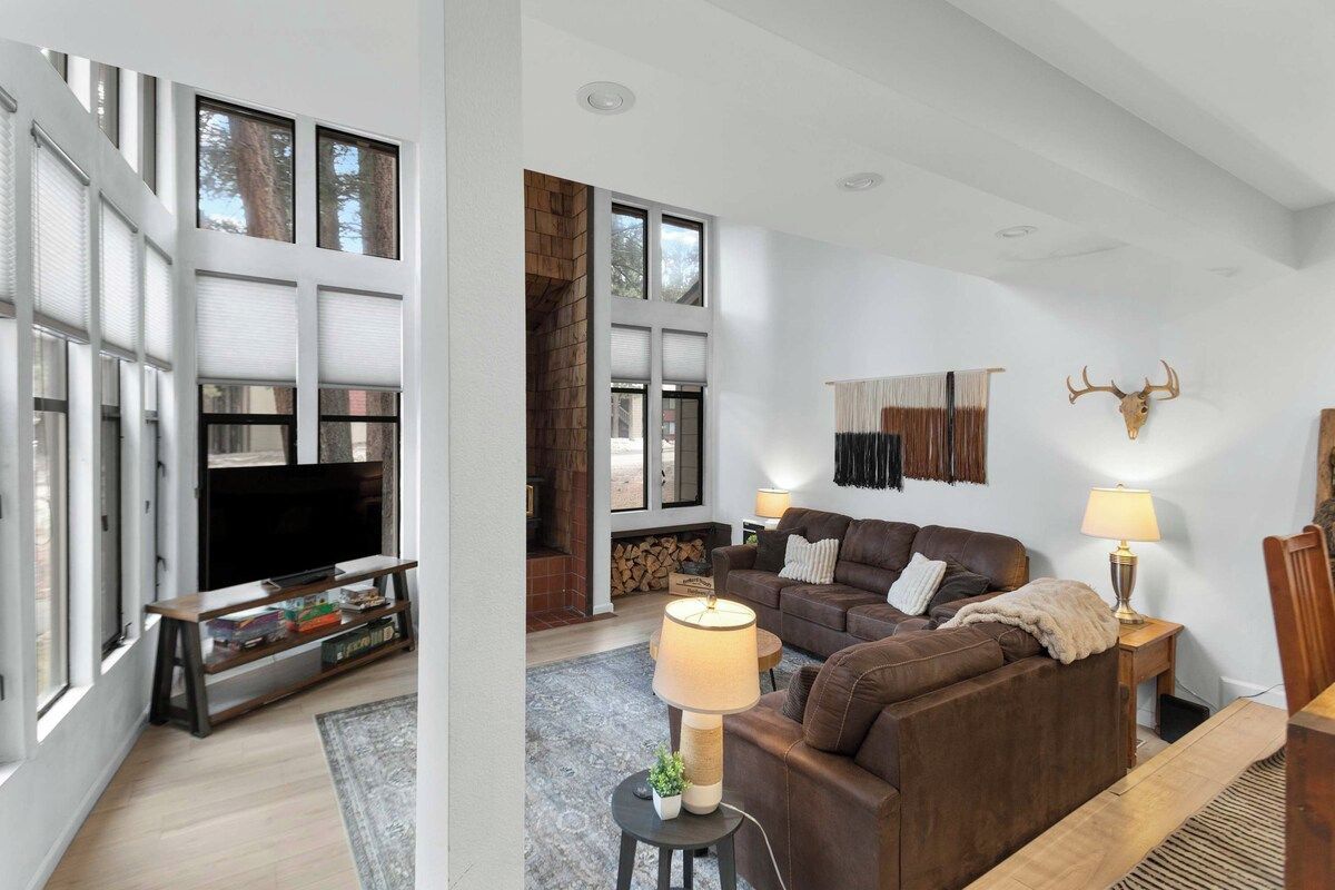 A modern living room with a fireplace, a television, and a sofa.