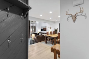 Ein modernes Interieur mit Essbereich, Holzmöbeln und einer Wanddekoration aus einem Hirschschädel.