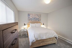 A bedroom with a bed, bedside tables, a dresser, and a wall-mounted artwork. - Pet Friendly 2Bd 2.5 Ba Modern Vacation Home (Mammoth Lakes)