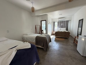 A room with two beds, a refrigerator, and a window with curtains. - VILA DO RIO (Santo Amaro do Maranhão)