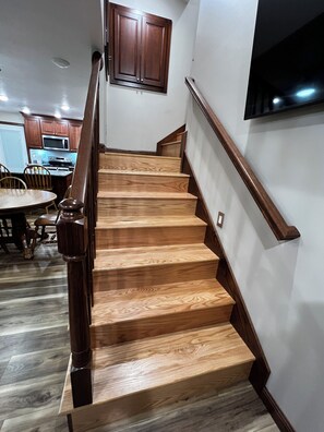 Una escalera de madera con barandilla que lleva a un descansillo.