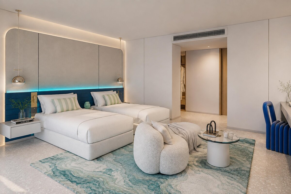 Ein modernes Schlafzimmer mit einem großen Bett, Nachttischen, einer Sitzecke und einem begehbaren Kleiderschrank.