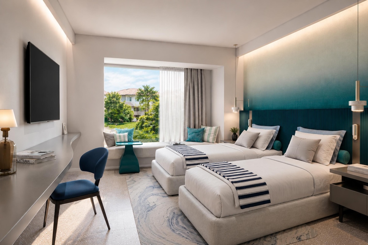Ein modernes Hotelzimmer mit einem großen Bett, einem Schreibtisch, einem Sessel und Blick ins Freie.