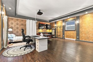 Un dormitorio moderno con cama, escritorio y silla, un baño con ducha, y un comedor con mesa y sillas.