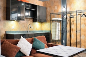 A modern kitchen with dark cabinets, a granite countertop, and a built-in oven. - Tranquil 2-bedroom house in charming Surrey perfect for relaxing stays (Surrey)