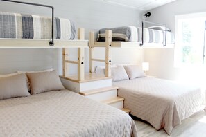 Ein Zimmer mit zwei Betten, einer Treppe und einem Fenster.