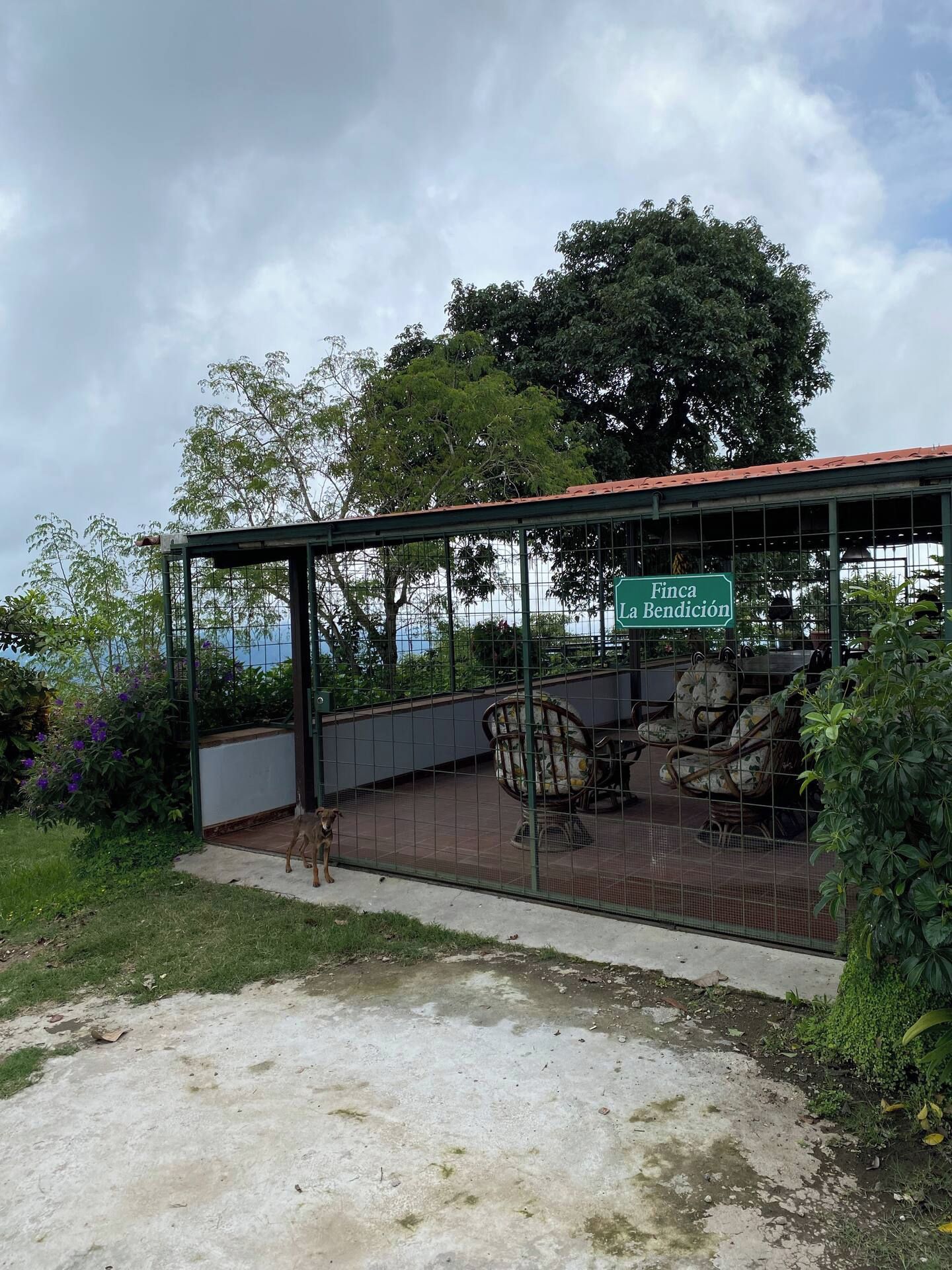 Et overdækket udendørs siddeområde med et skilt, der viser 'Finca La Bendición'.