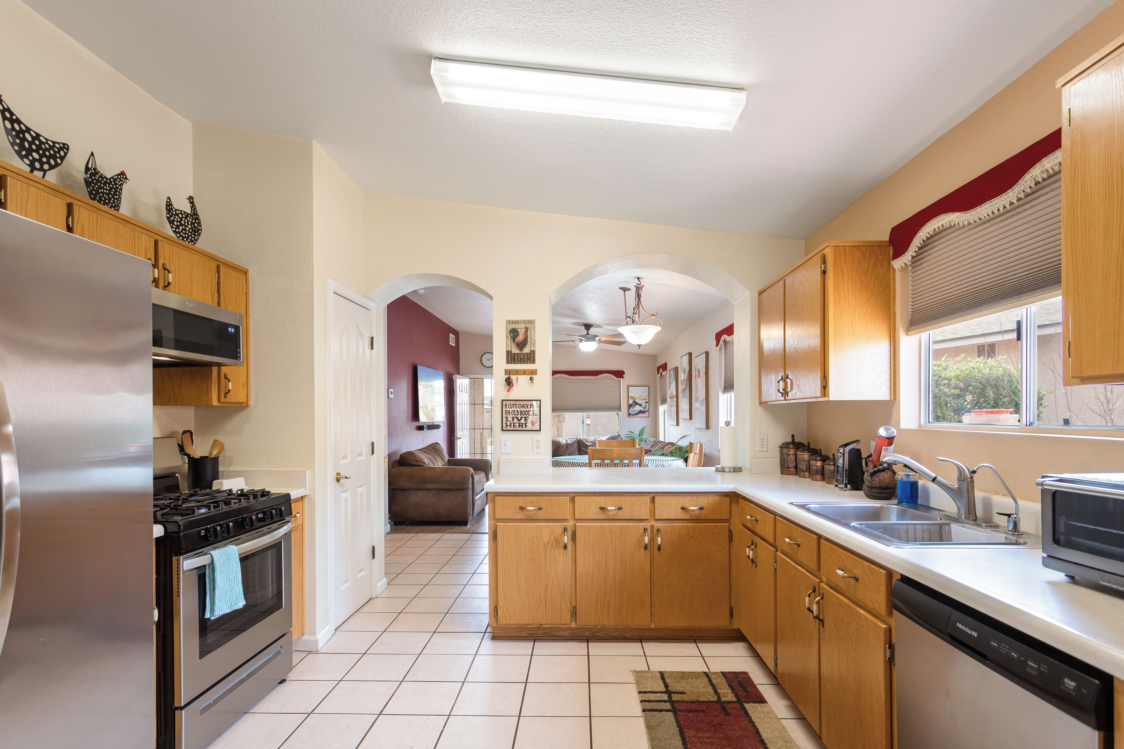 Una cocina con gabinetes de madera, electrodomésticos de acero inoxidable y una isla grande con un lavamanos.