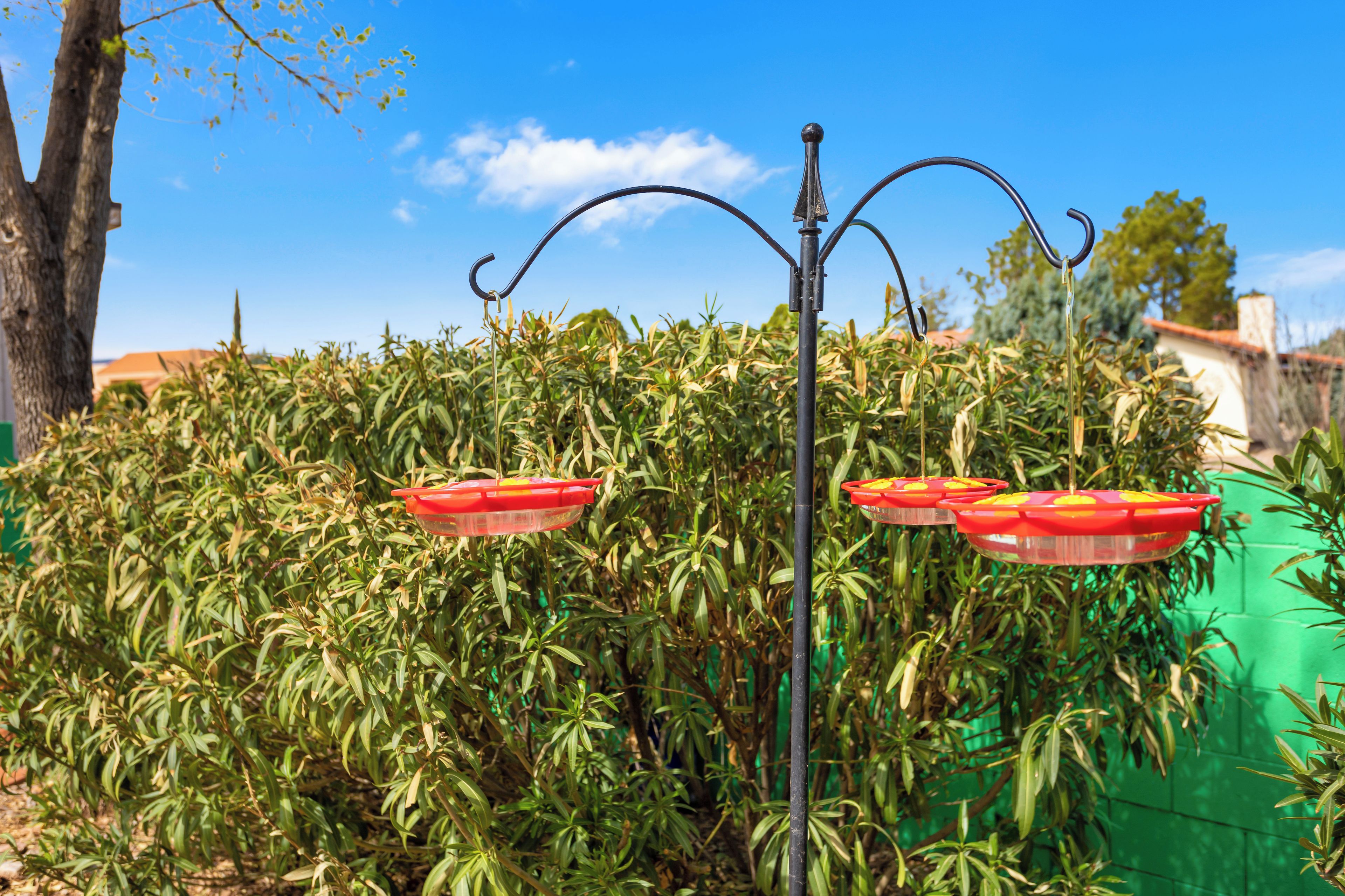 Un lampadaire en métal avec trois lampes rouges en forme de fleurs.
