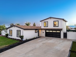 A two-story house with a garage, a driveway, and a well-maintained lawn. - Casa Anduro 5BR Pool & Spa Near San Diego (Chula Vista)