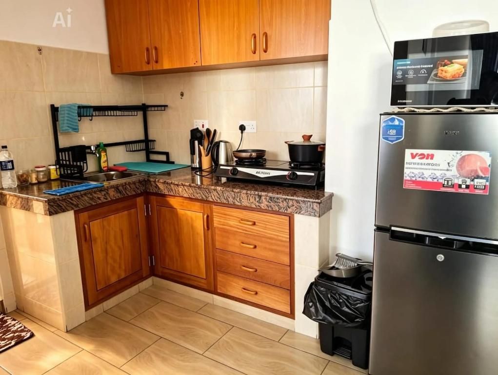 A kitchen with wooden cabinets, a stainless steel refrigerator, and a stove.