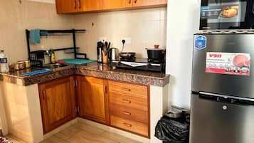A kitchen with wooden cabinets, a stainless steel refrigerator, and a stove.