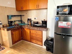 A kitchen with wooden cabinets, a stainless steel refrigerator, and a stove.