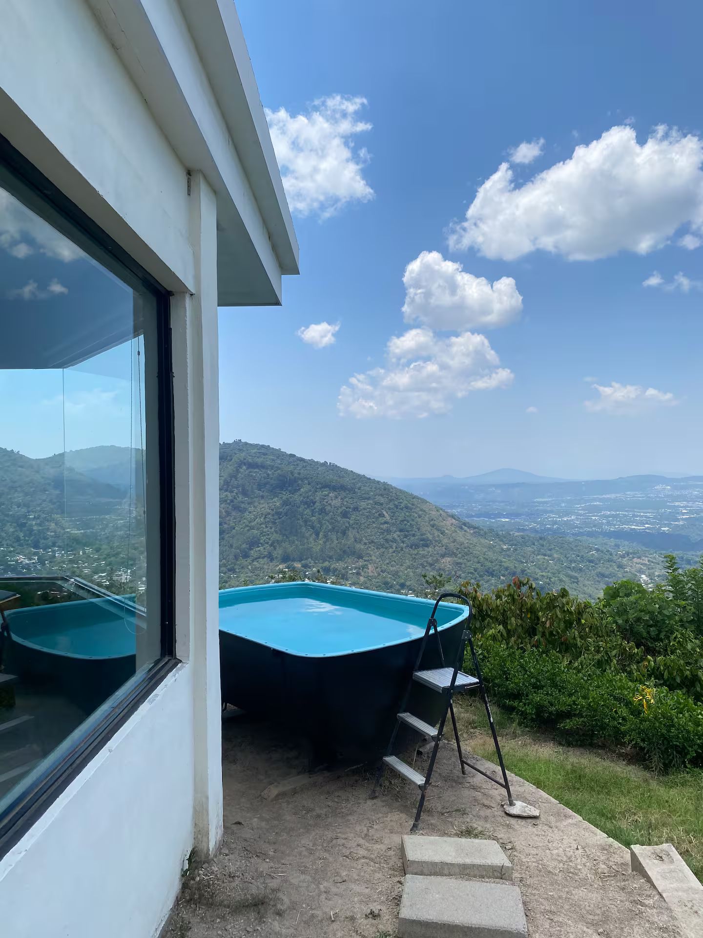 Un edificio moderno con piscina e vista su un paesaggio collinare.
