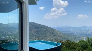 Un edificio moderno con piscina e vista su un paesaggio collinare.