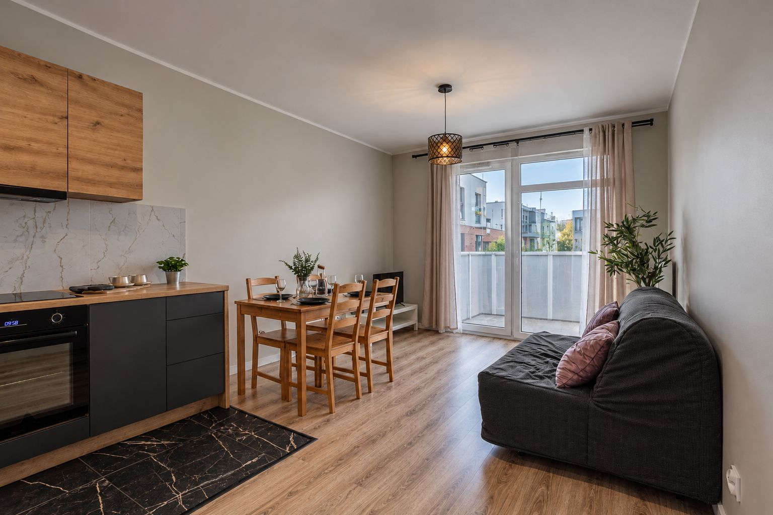 Una cocina moderna con comedor, un sofá y un balcón con vistas.