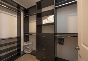 Un vestidor amplio con varios estantes, cajones y espacio para colgar ropa.
