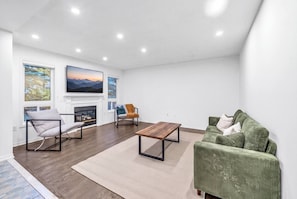 A modern living room with a fireplace, seating, and artwork. - Minutes to Thermëa Spa, Hwy 401, GO Train & Golf (Ajax)